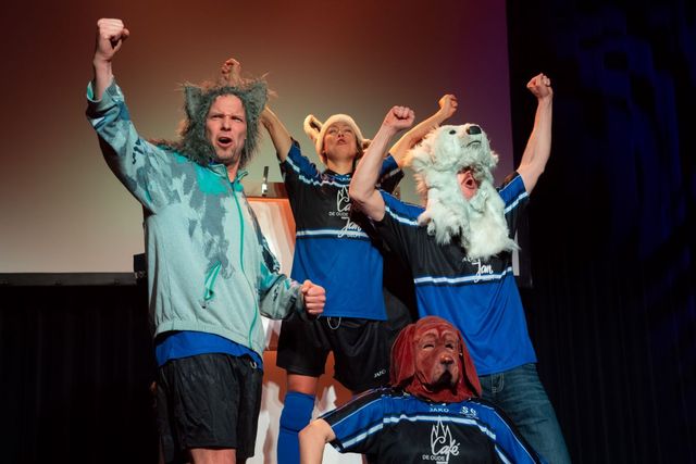 spelers theater Knars staan met vuist in de lucht alsof zij gewonnen hebben