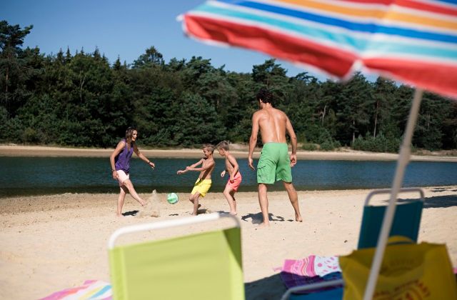 Kinderen voetballen op het strand bij de Kibbelkoele.