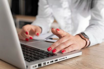 Stockfoto aanmelden evenement - vrouw aan het typen achter laptop