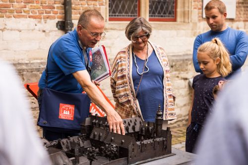 Een gids geeft uitleg over het Markiezenhof bij de maquette op de binnenplaats.