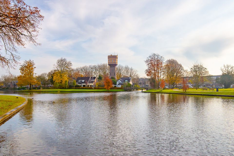 Stadspark Westdampark in Woerden, Groene Hart, met de historische watertoren achter de waterpartij en bomen in herfstkleuren.