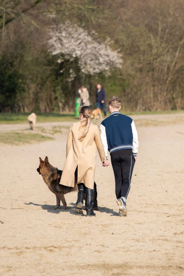 koppel hand in hand aan het lopen op het strand.