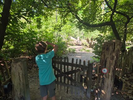 Jongetje opent het houten hek van de natuurspeeltuin OERRR