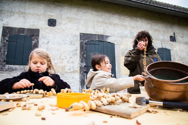 Kinderen rijgen pinda's aan een touw.