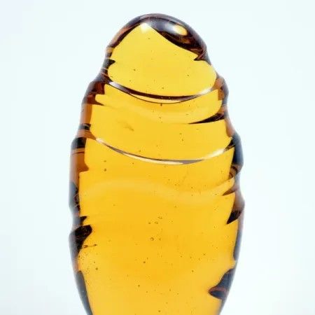 Geel/goud kleurige ovale glas sculptuur met de titel 'the long and winding road to Neverland 2026' .