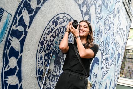 Jongedame maakt een foto met haar camera in de Bonte Ossteeg in Delft in de zomer