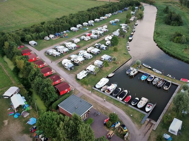 Luftaufnahme des Geländes von Camping Pasveer mit Campingplatz und Hafen.