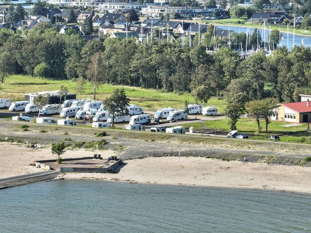 Verschillende campers op vakantiepark Lemmer met op de voorgrond de zee en het strand.