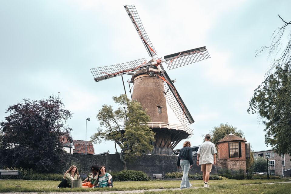 Historische korenmolen De Windotter IJsselstein, Groene Hart, monumentale windmolen met draaiende wieken, bezoekers wandelen en ontspannen in het groene stadspark aan de voet van de molen.