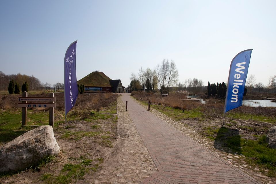 Een lang pad die naar de ingang van een bezoekerscentrum loopt.