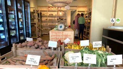 Winkel Oogst Shop Woerden, provincie Utrecht, Groene Hart, houten kisten met aardappelen, wortels, bananen en bloemkool in een duurzame streekwinkel waar klanten lokale producten uitzoeken.