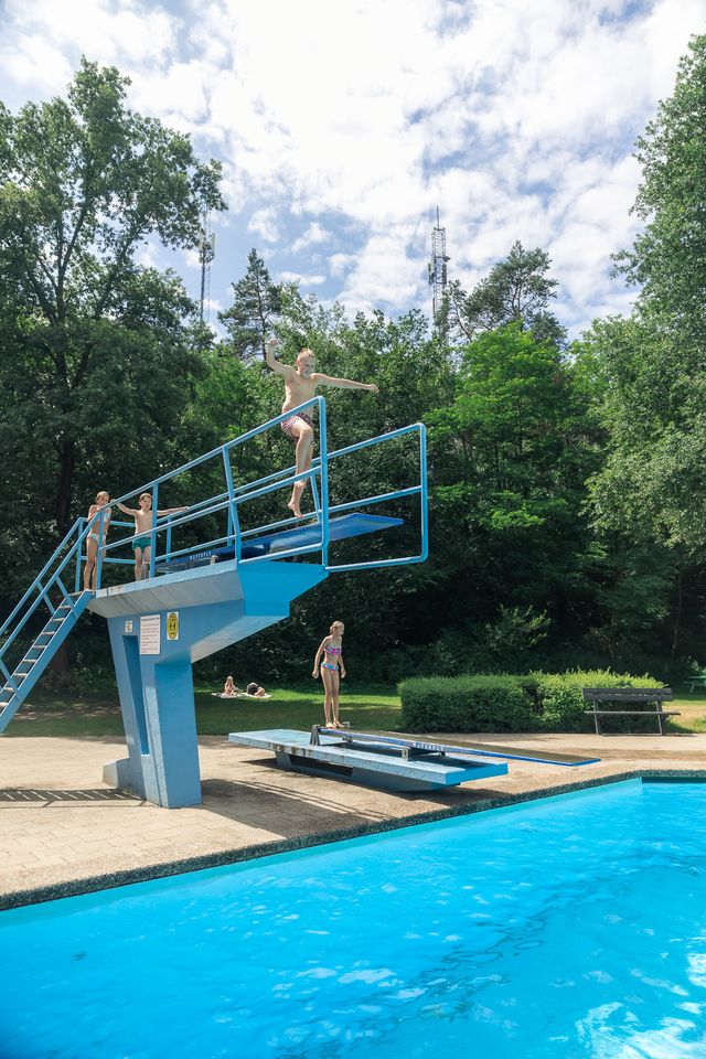 Kind springt van een duikbad in Bosbad Leersum