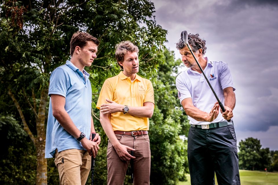 Drie mannen met golfsticks in hun hand