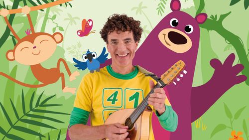 Een man met een gitaartje in zijn hand en op de achtergrond de getekende dieren