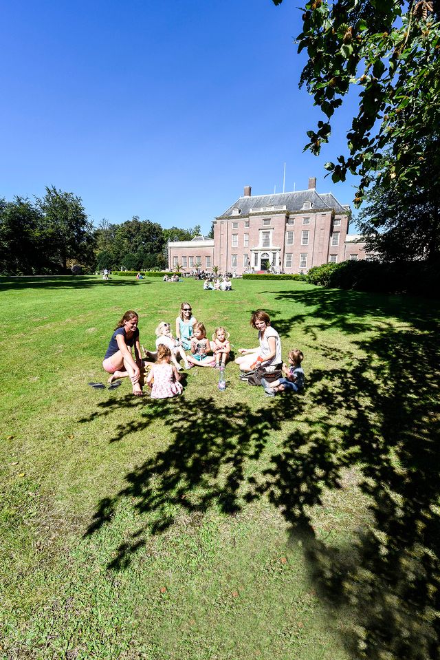 Een gezin is aan het picknicken in de tuinen rondom Slot Zeist