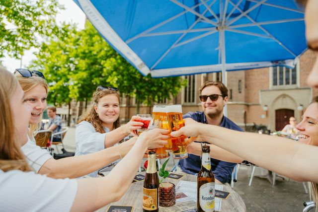 Proosten met bier op terras