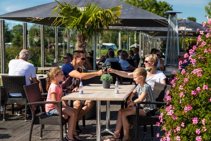 Een gezin van vier op het terras bij de brasserie op RCN Vakantiepark de Potten.