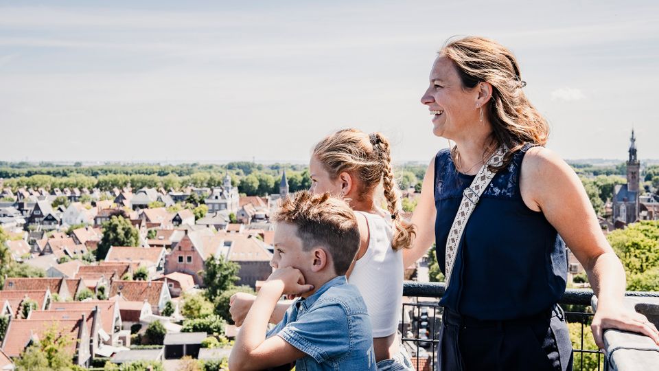 Een moeder met twee kinderen die naar het uitzicht kijken vanaf De Grote Kerk in Edam