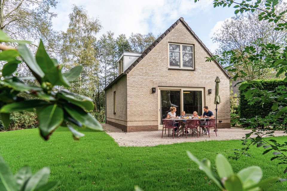Vooraanzicht van stenen bungalow op het park