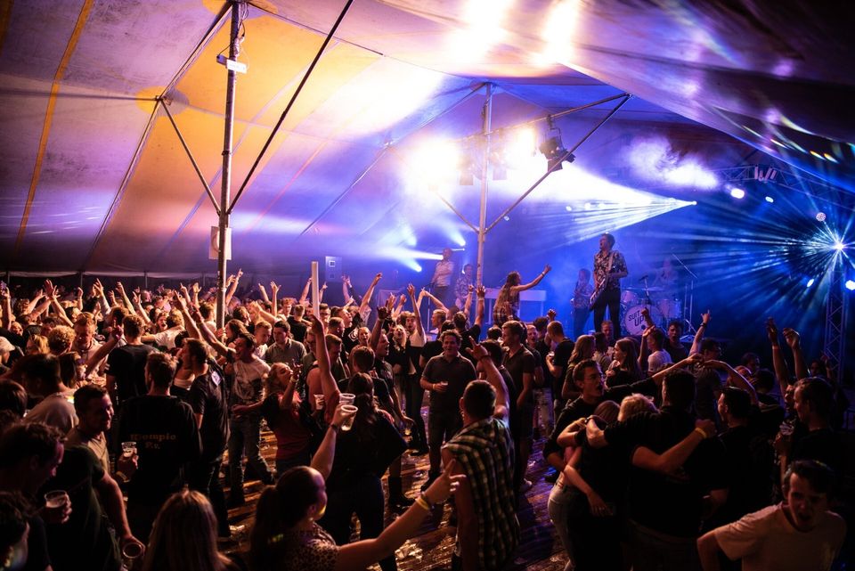 Drukbezocht tentfeest van Crespon in Harmelen, gemeente Woerden, in het Groene Hart met live band, festivalverlichting en dansende bezoekers tijdens een avond vol muziek en uitgaan.