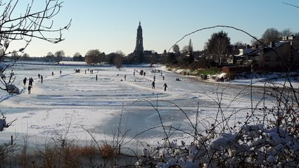 Uitzicht Cunerakerk en ijs met schaatsers
