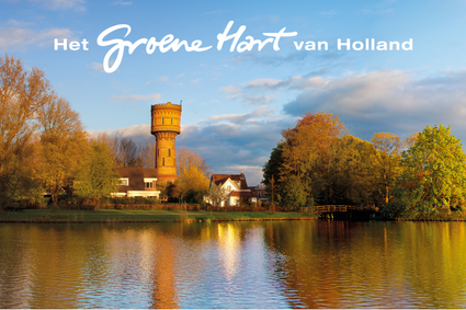 Historische watertoren in Woerden, Groene Hart van Utrecht, omringd door bomen in herfstkleuren, met een houten brug en weerspiegelingen in het water. Bovenaan staat de tekst ‘Het Groene Hart van Holland’.