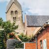 Een vrouw die een foto maakt van de Walfriduskerk in Bedum