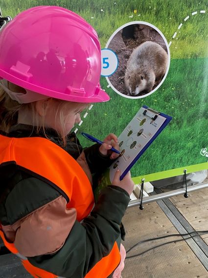 Meisje met veiligheidshelp en hestje en bloke note met pen.