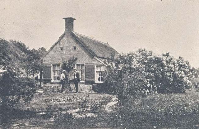 Ein Koloniehaus in Drenthe, vor dem Menschen stehen.