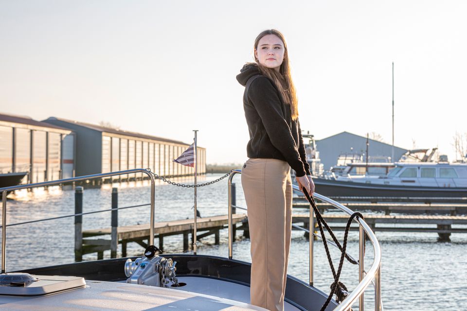 Meisje gooit de trossen los van motorboot.