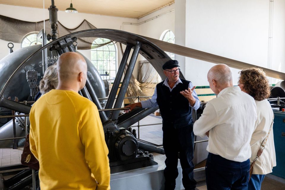 Wisboomgemaal, Kinderdijk, Alblasserdam, Zuid-Holland, Groene Hart, historisch stoomgemaal waar een gids bezoekers rondleidt langs grote machines en waterstaatserfgoed op UNESCO Werelderfgoed Kinderdijk.