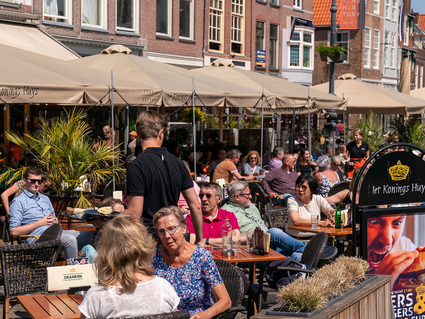 Veel mensen die op het terras zitten van Het Koningshuys