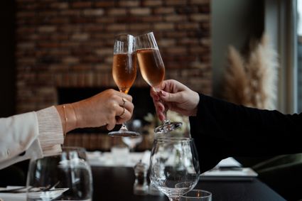 Twee glazen bubbels waarmee geproost wordt in een restaurantsetting bij 't Schippershuis in Terherne.
