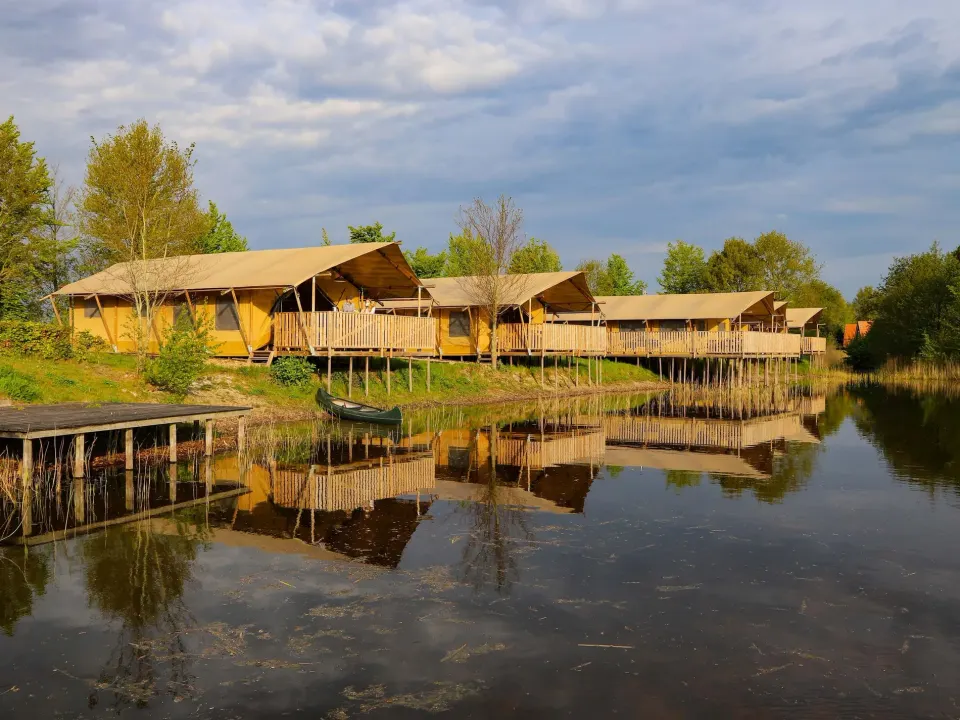 Drie safaritenten naast elkaar aan het water op Vakantiepark Eigen Wijze in Bant.