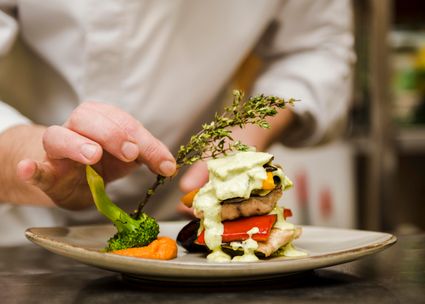 Chef die een gourmet maaltijd serveert