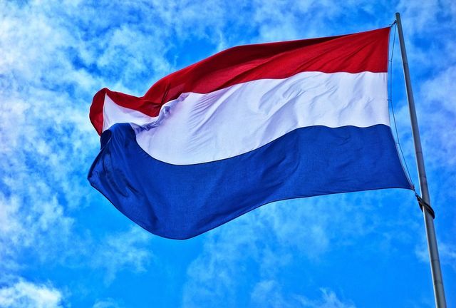 Dutch flag with the sky in the background.