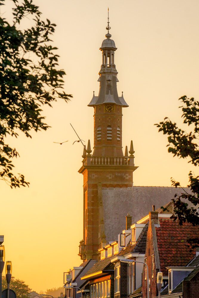 een foto van de nieuwe kerk in katwijk met een zonnnetje