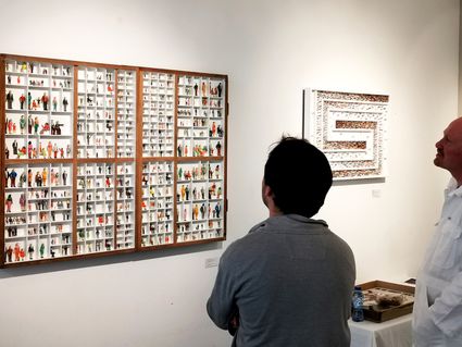 Mensen die binnen bij Art Gallery Rene Jacobs kunstwerken bewonderen