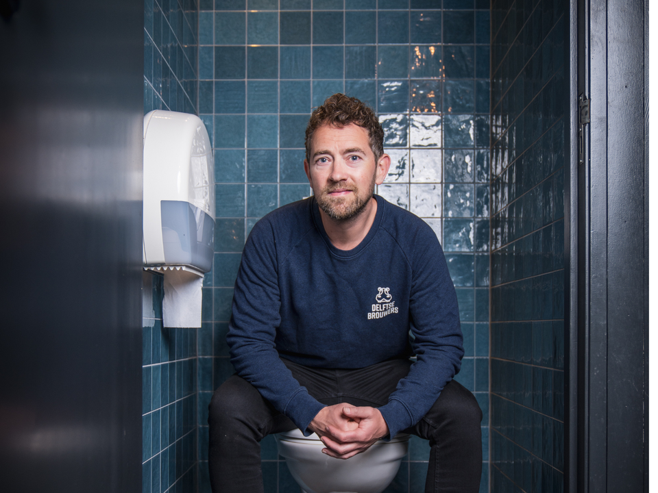 Jon Cornelese op het toilet bij het Delfts Brouwhuis voor een interview over toilettoegankelijkheid in Delft