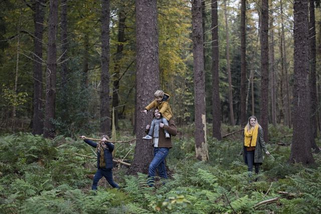 Een gezin met twee kinderen wandelt door een bos in Drenthe.