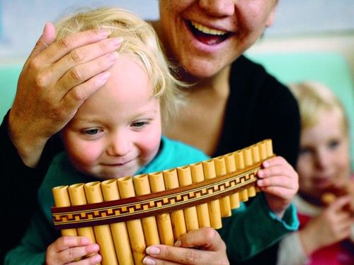 Kindje die een instrument bespeelt