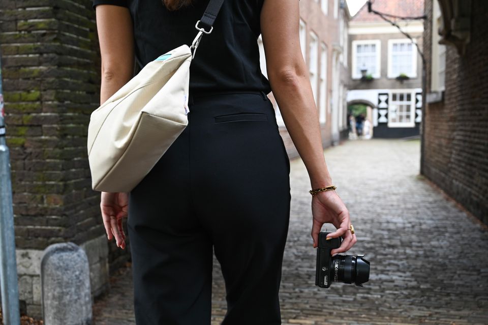 Dame met fototoestel in de hand loopt door steeg