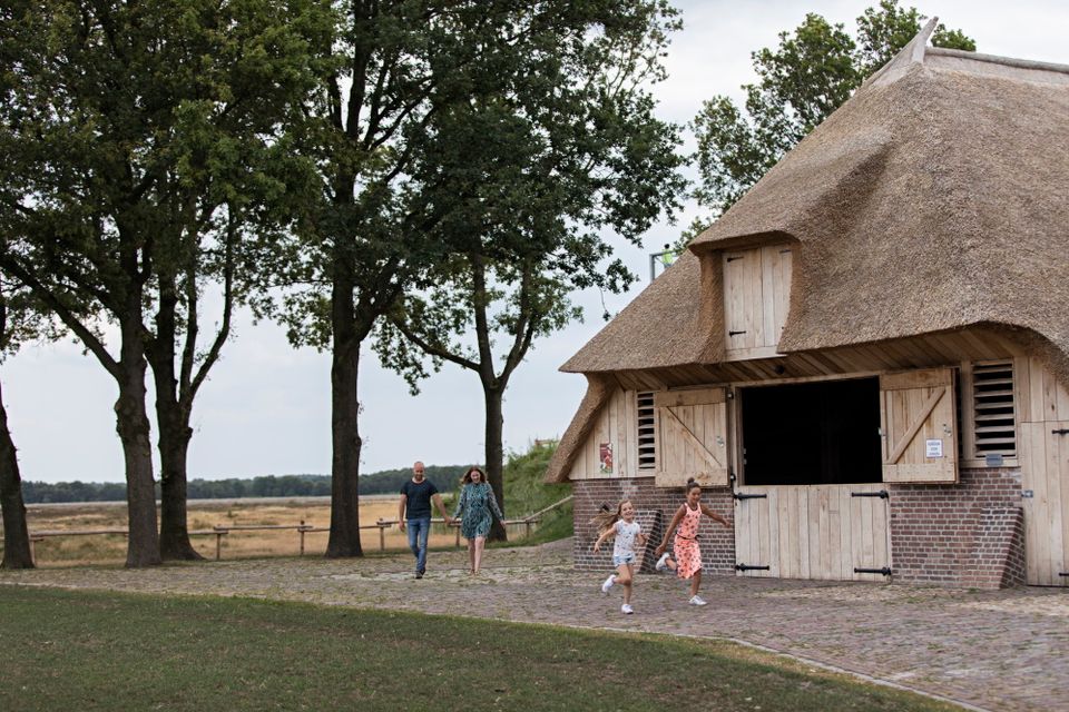 Die Kinder rennen vor den Eltern her zu einem Schafstall in Drenthe.