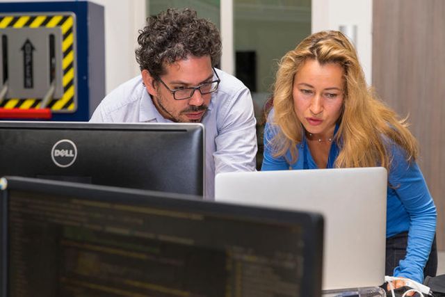 Man en vrouw aan het werk achter PC.