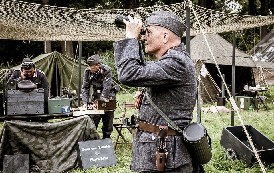 Militair die door een verrekijker kijkt.