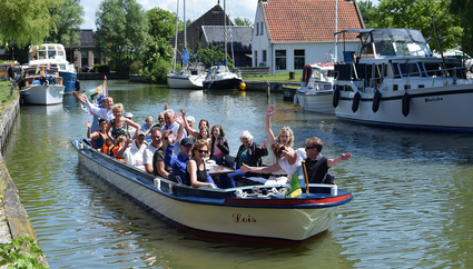 een groep mensen die op een sloep zitten.