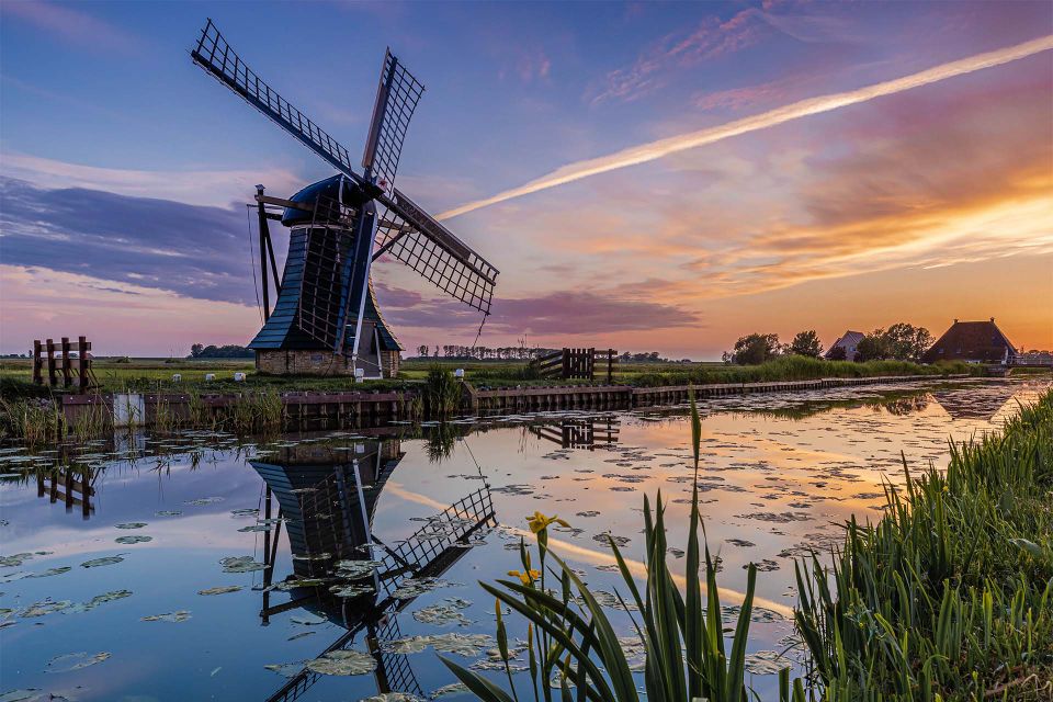 ybema molen met mooie reflectie in het water tijdens zonsondergang