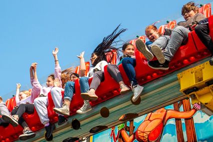 Lachende en gielende kinderen in de kermis attractie 'de bank'.