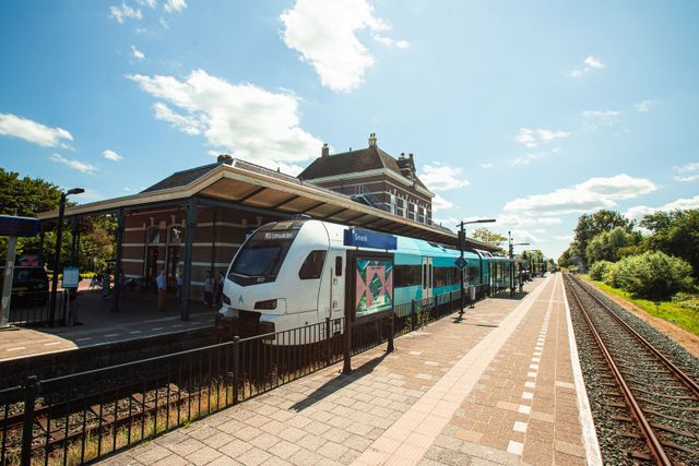 Een trein van Arriva op het spoor voor station Sneek.