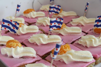 stukjes oranjekoek met slagroom en een fries vlaggetje